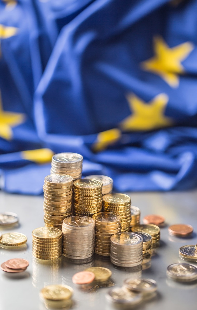 drapeau européen en arrière-plan tas de pièces d'argent en avant-plan