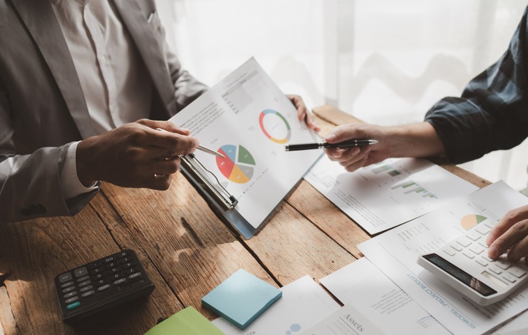 échange entre deux personnes sur un schéma calculettes feuilles sur un bureau
