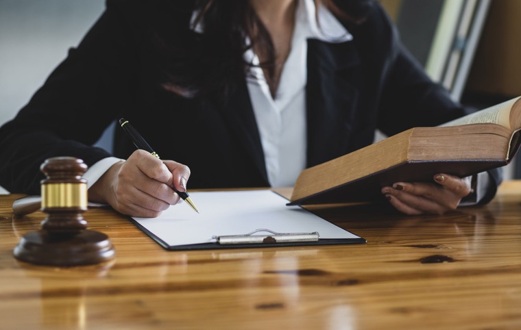 une personne signe un document marteau de justice