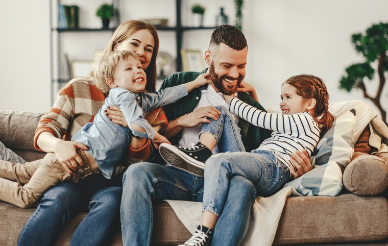 couple avec leurs deux enfants assis sur un canapé