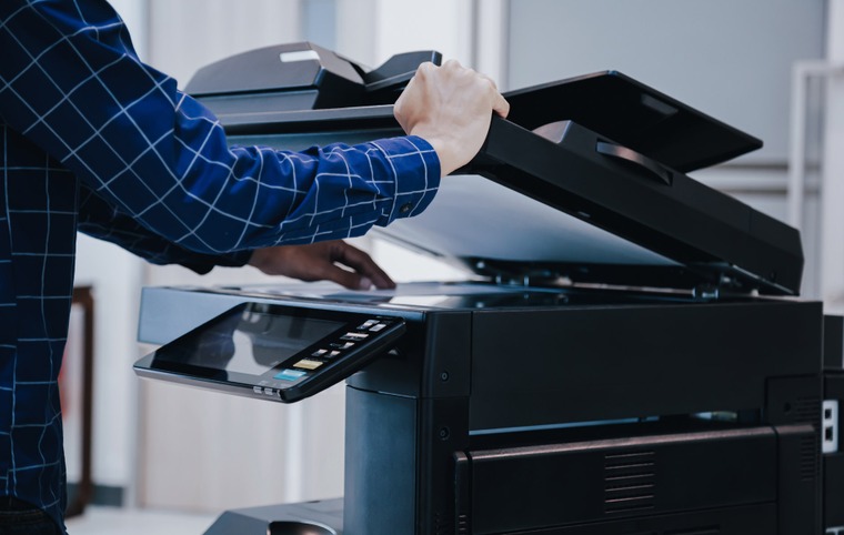 personne dispose une feuille dans une imprimante