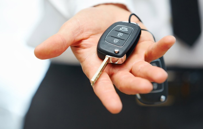une personne tient un clé de voiture en main