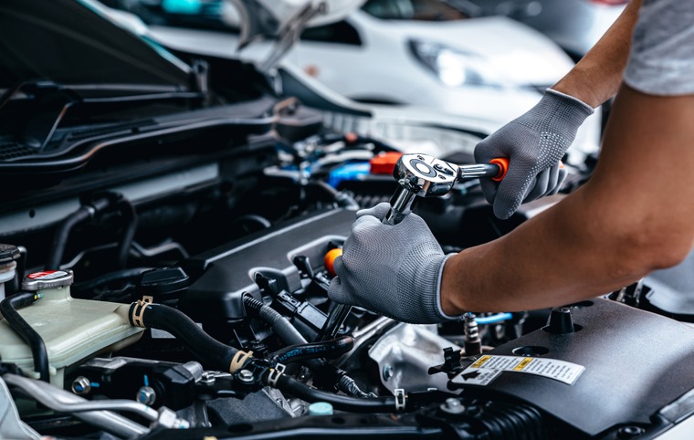 mécanicien mains dans le moteur d'une voiture